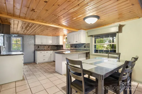 a kitchen with a table chairs microwave and cabinets