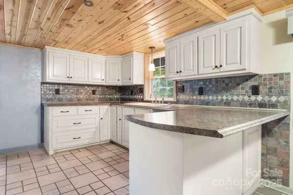 a kitchen with granite countertop a sink a stove and cabinets