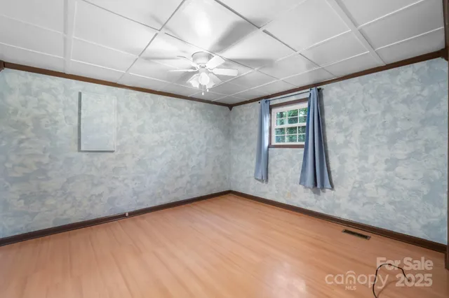 a spacious bedroom with a bed and wooden floor