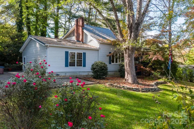 a view of a house with a yard and tree s