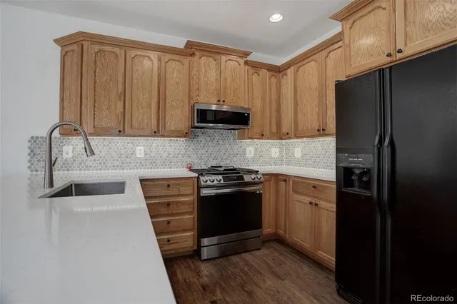 a kitchen with stainless steel appliances granite countertop a refrigerator and a sink