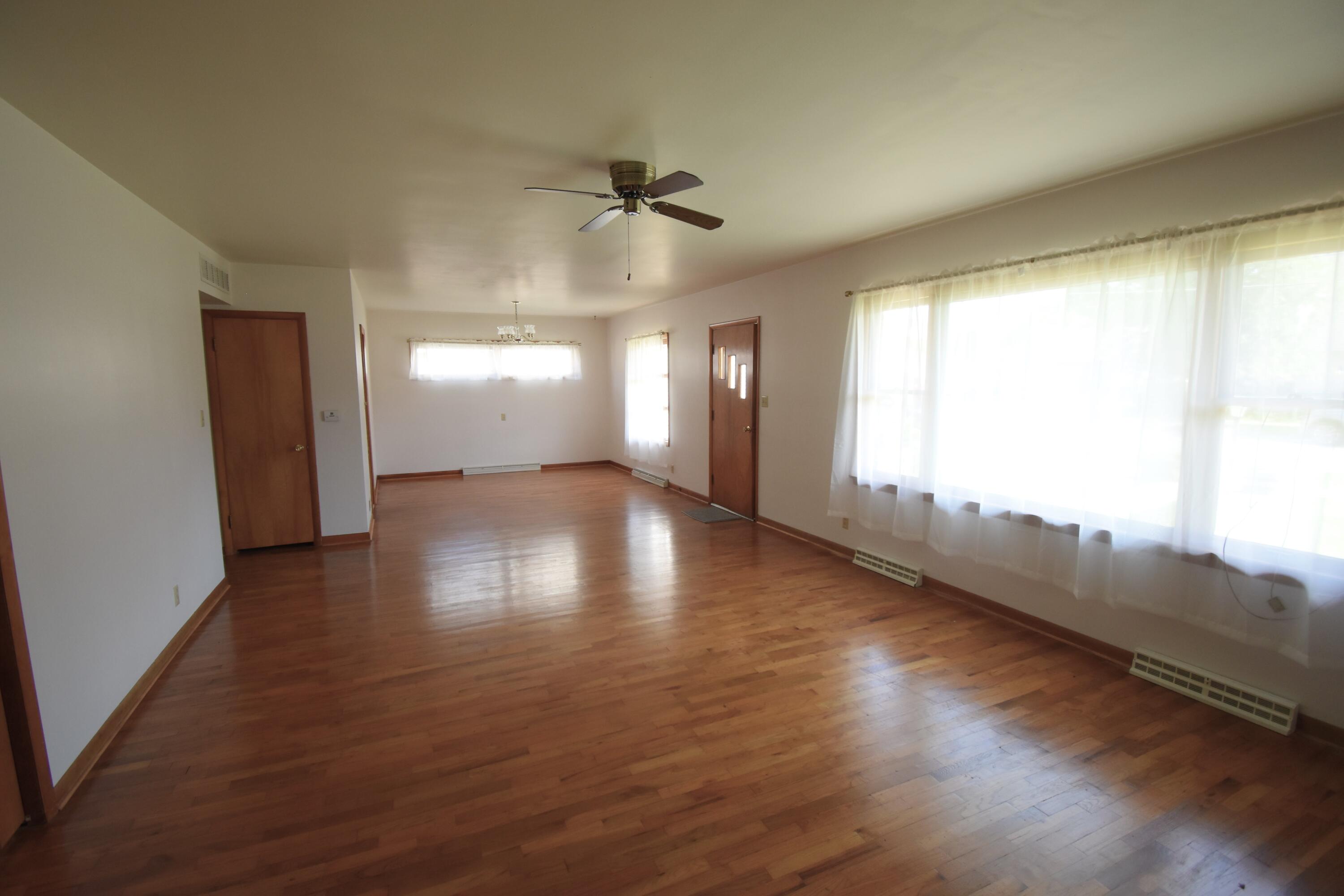 328 South Weston Street Rensselaer, IN 47978 - Photo 4 of 39 a view of an empty room with wooden floor and a window