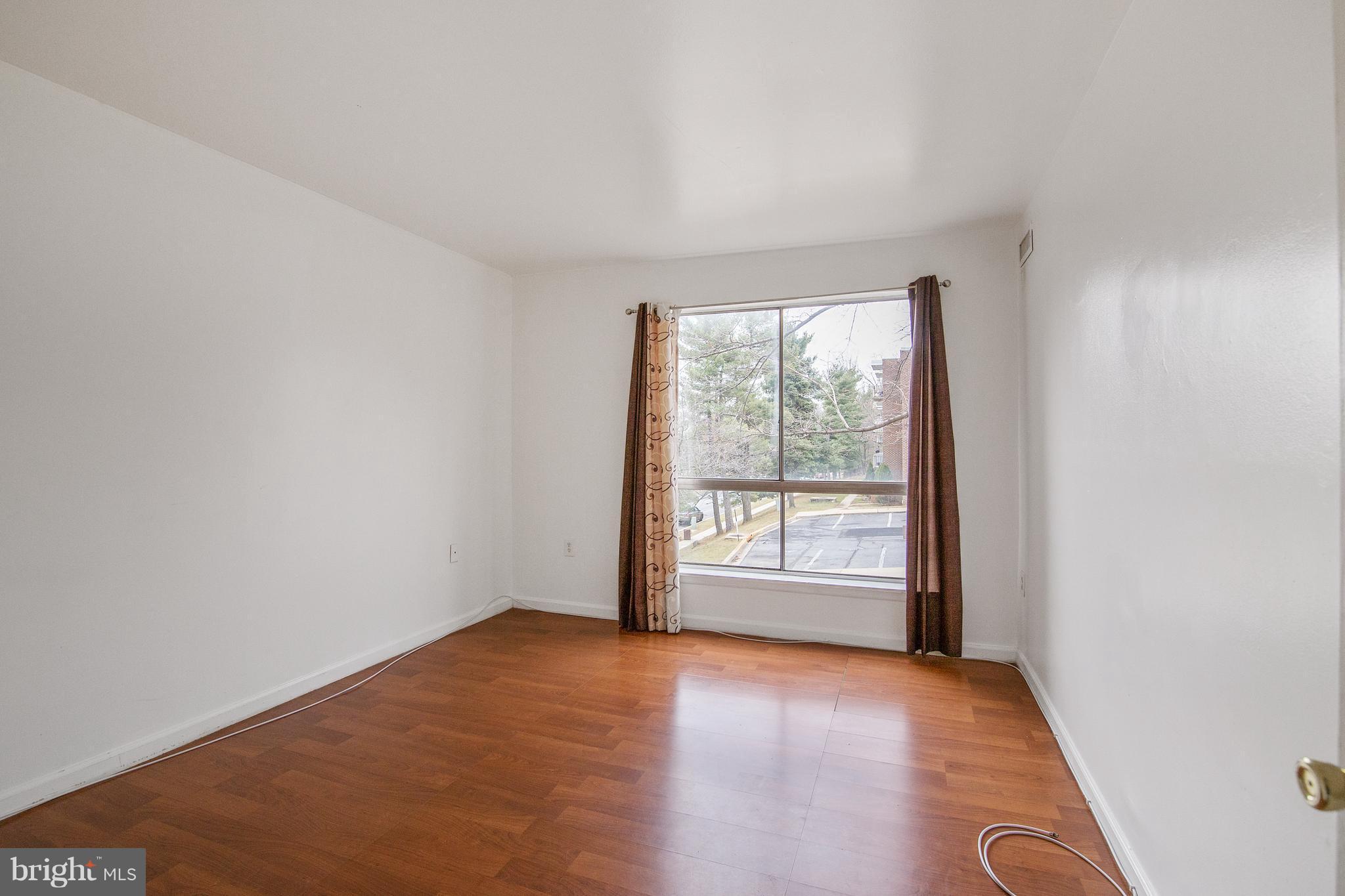 3946 Bel Pre Road, Unit 4 Silver Spring, MD 20906 - Photo 10 of 12 an empty room with wooden floor and windows