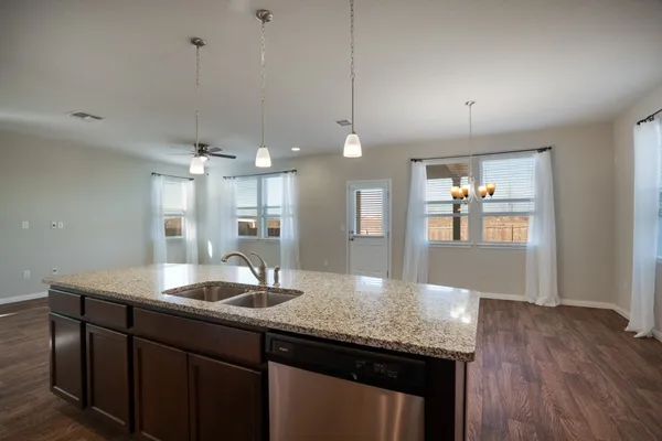 a kitchen with kitchen island a wooden floor and refrigerator