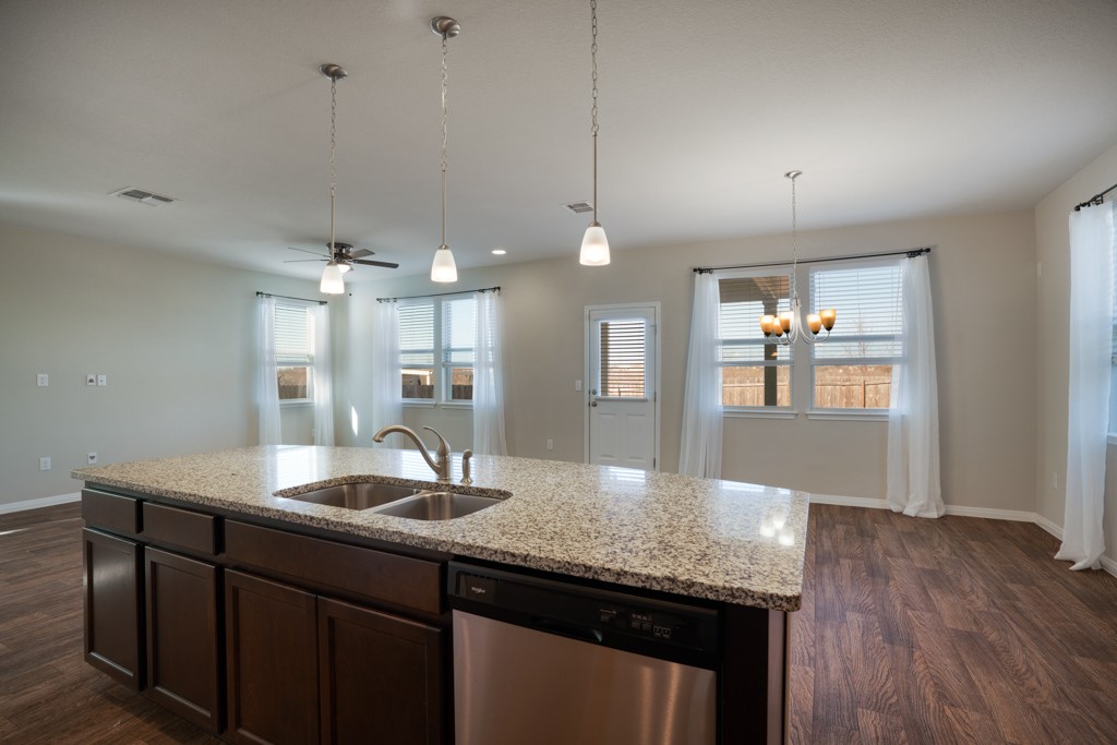 205 Guemal Road Buda, TX 78610 - Photo 9 of 33 a kitchen with granite countertop a sink cabinets and wooden floor