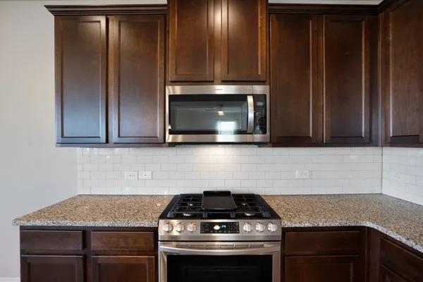 a kitchen with stainless steel appliances granite countertop a sink and stove top oven