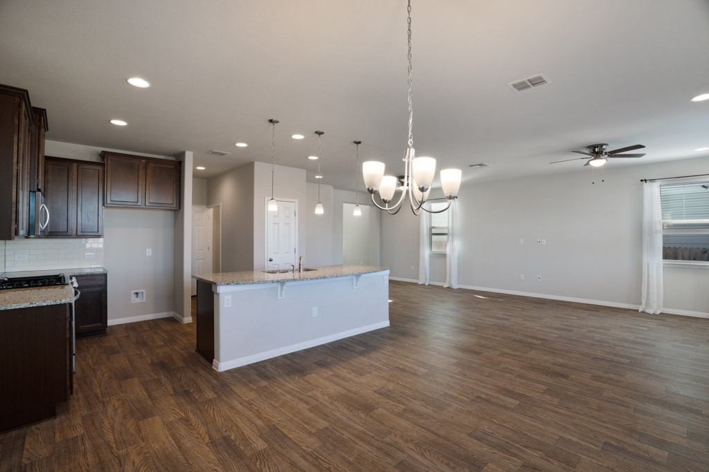 205 Guemal Road Buda, TX 78610 - Photo 33 of 33 a large kitchen with kitchen island a island wooden floor stainless steel appliances and cabinets