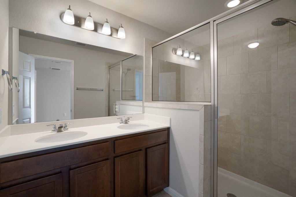 205 Guemal Road Buda, TX 78610 - Photo 20 of 33 a bathroom with a double vanity sink and a mirror