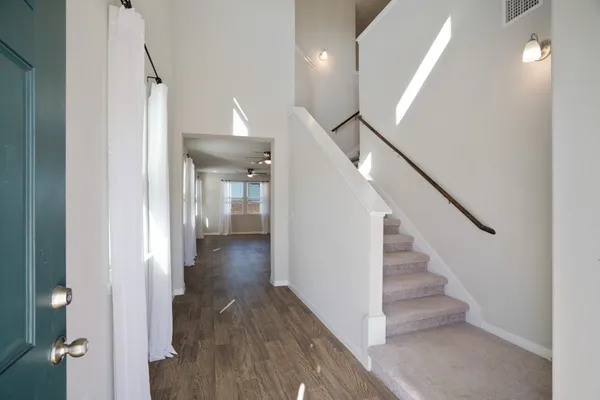 a view of a hallway with wooden floor and staircase