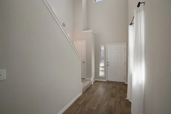 a view of a hallway with wooden floor and entryway