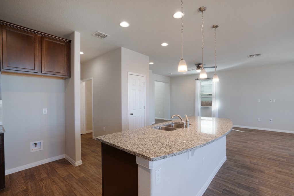 205 Guemal Road Buda, TX 78610 - Photo 8 of 33 a kitchen with kitchen island a wooden floor and refrigerator