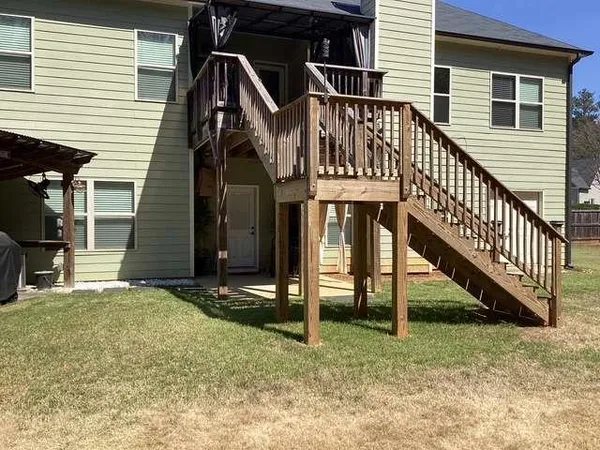 a view of a house with backyard and deck