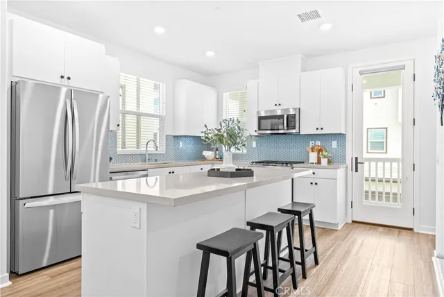 a kitchen with stainless steel appliances granite countertop a refrigerator and a stove top oven