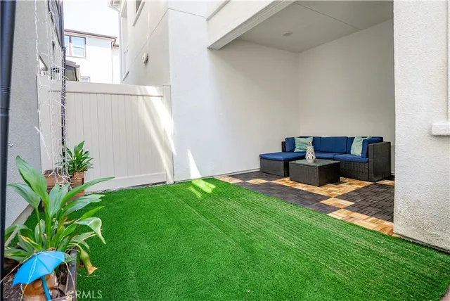 a backyard of a house with table and chairs with wooden fence