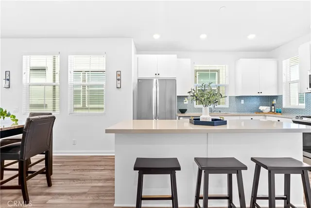 a kitchen with a table chairs refrigerator and window