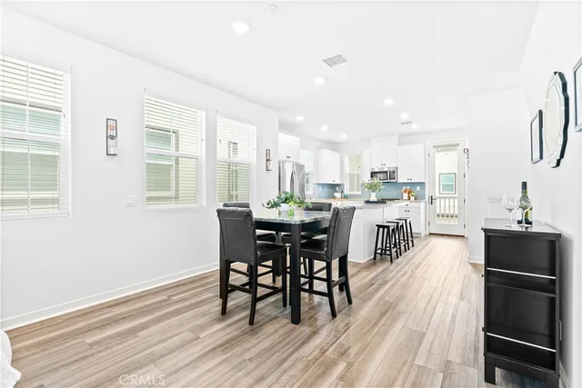 a kitchen with a dining table chairs and refrigerator