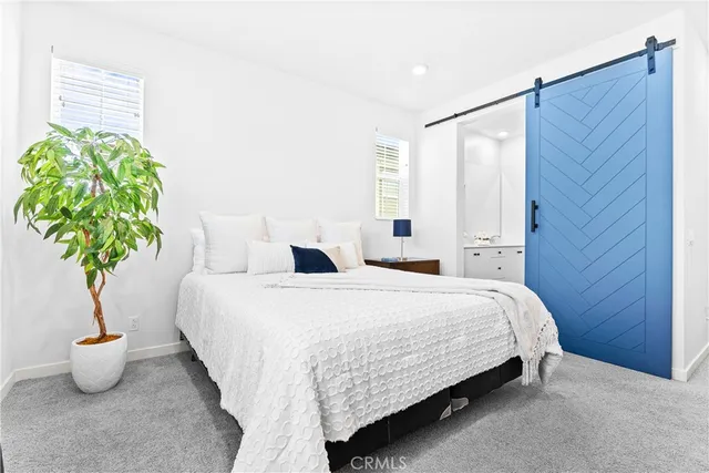 a bedroom with a bed and a potted plant