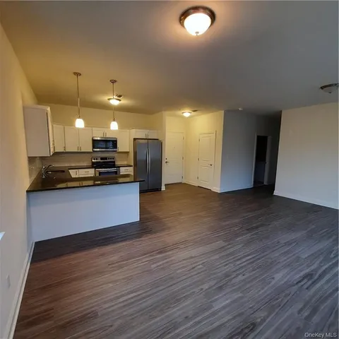 a view of kitchen with refrigerator stove and wooden cabinets