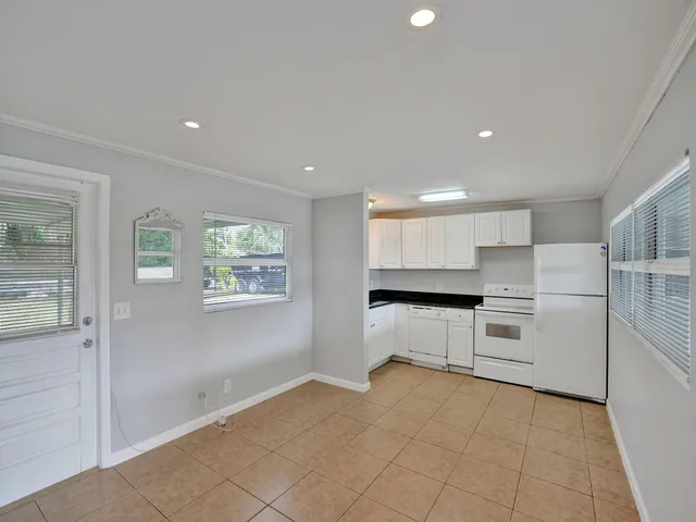 a kitchen with a refrigerator and white cabinets