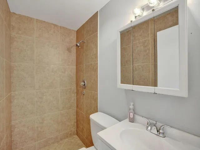 a bathroom with a sink a toilet and shower