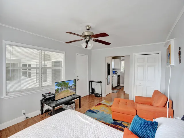 a living room with furniture a ceiling fan and a window