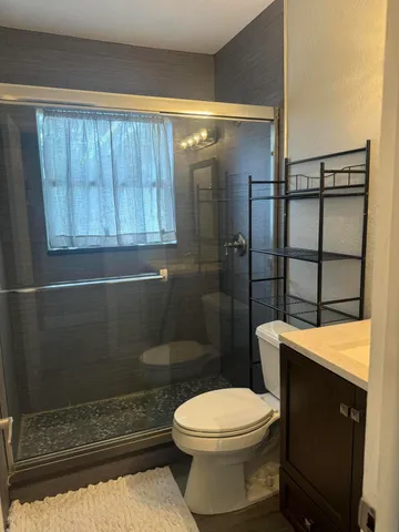 a bathroom with a toilet a sink and shower