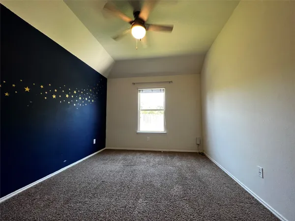 en empty room with windows and chandelier fan
