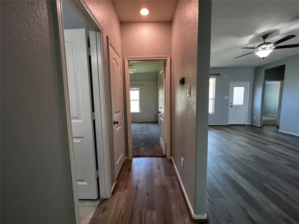 a view of a hallway with wooden floor