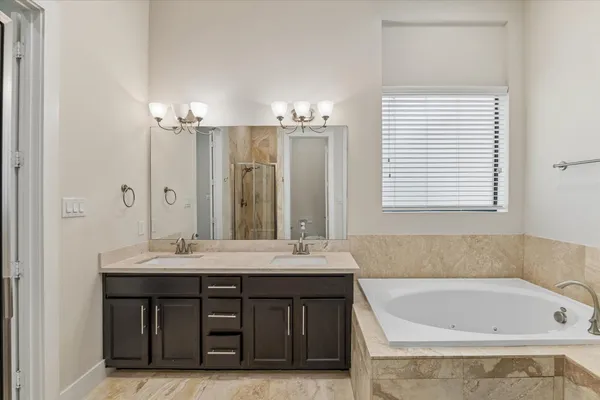 a bathroom with a sink double vanity granite tub and a mirror