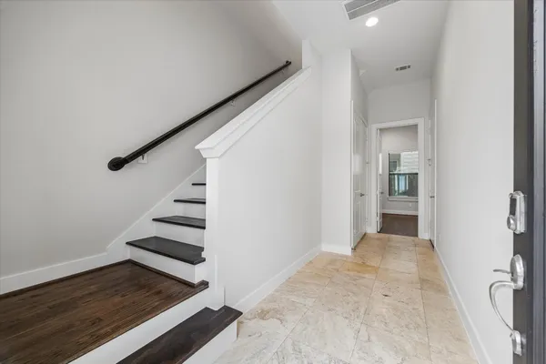 a view of a hallway with wooden floor and entryway