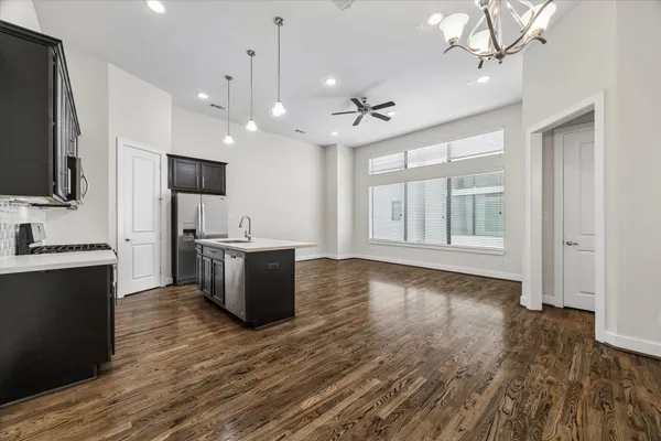 a kitchen that has a sink a stove and a wooden floor
