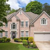 a house view with a garden and large trees