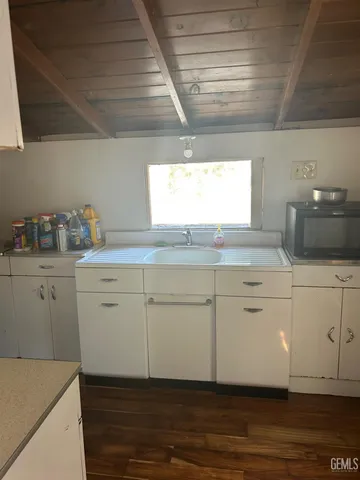 a kitchen with granite countertop white cabinets and white appliances