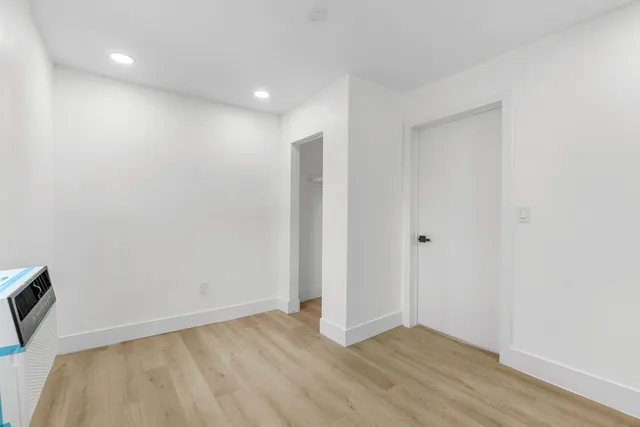 a view of an empty room with wooden floor