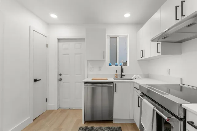 a kitchen with stainless steel appliances granite countertop a refrigerator a sink and a stove