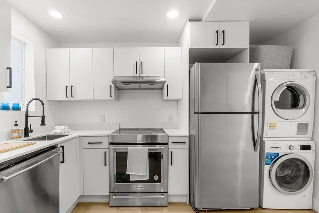 a kitchen with stainless steel appliances granite countertop a refrigerator and a stove