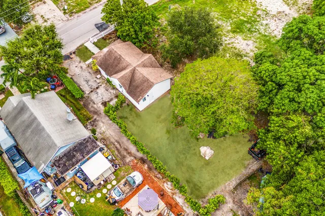 an aerial view of residential houses with outdoor space and trees