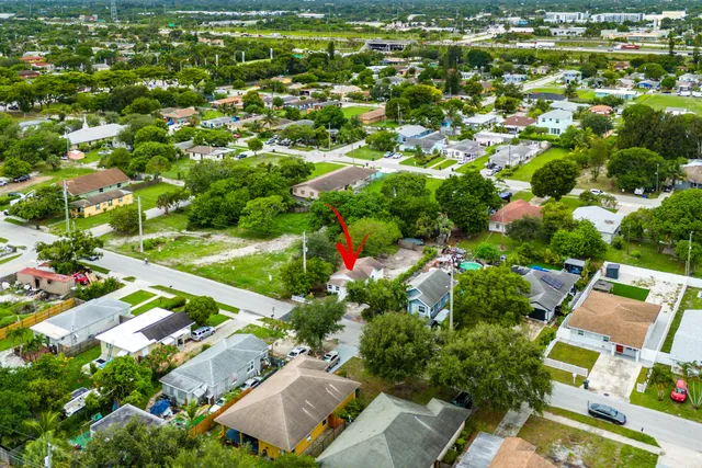 an aerial view of residential houses with outdoor space and trees