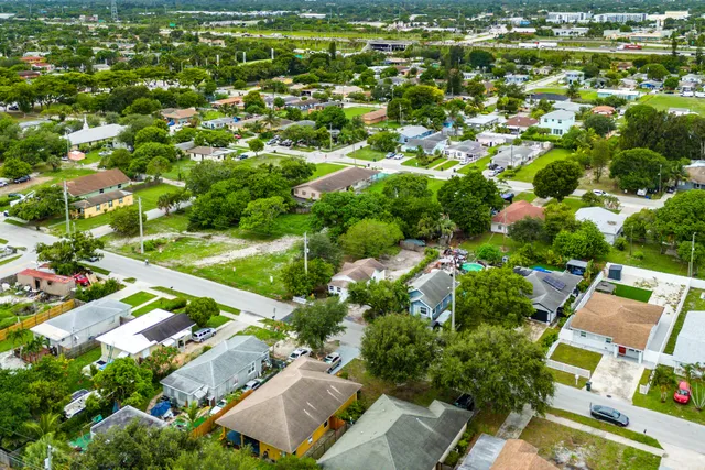 an aerial view of residential houses with outdoor space and trees