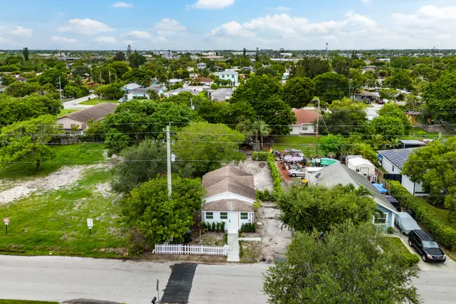 an aerial view of residential houses with outdoor space and trees