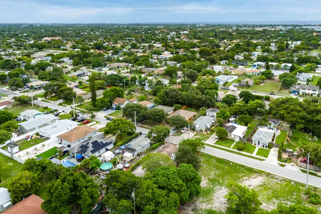 an aerial view of residential houses with outdoor space and trees