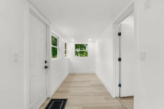a view of a hallway with wooden floor and staircase