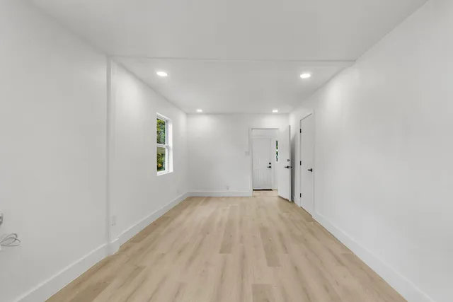 a view of a big room with wooden floor and windows