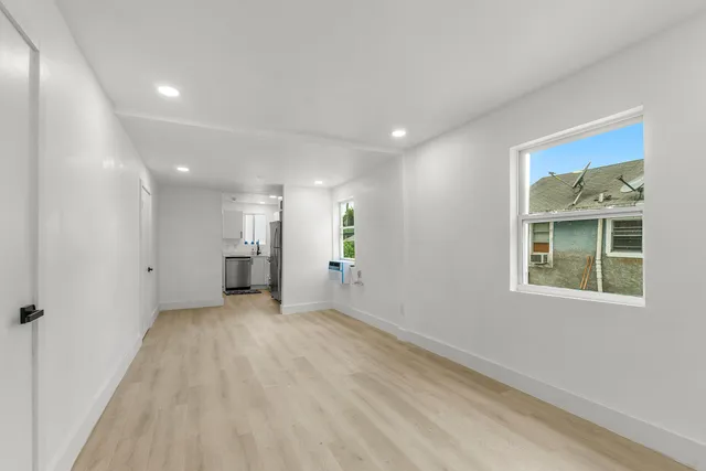 a view of a big room with wooden floor and windows