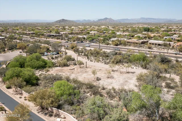 an aerial view of residential houses with outdoor space and trees