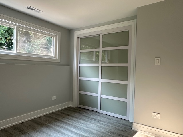906 Revere Road Glenview, IL 60025 - Photo 25 of 32 a view of an empty room with a window and wooden floor