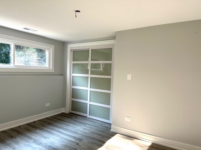 906 Revere Road Glenview, IL 60025 - Photo 26 of 32 a view of an empty room with a window and wooden floor