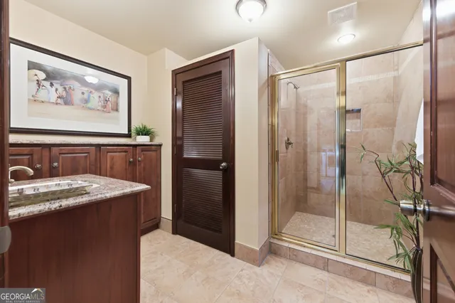 a bathroom with a granite countertop sink a mirror and a shower