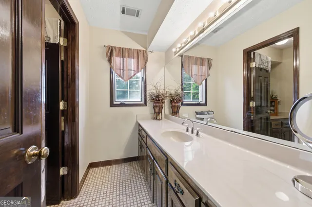 a bathroom with a double vanity sink a mirror and a shower
