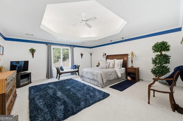 a bedroom with a large bed and a chandelier